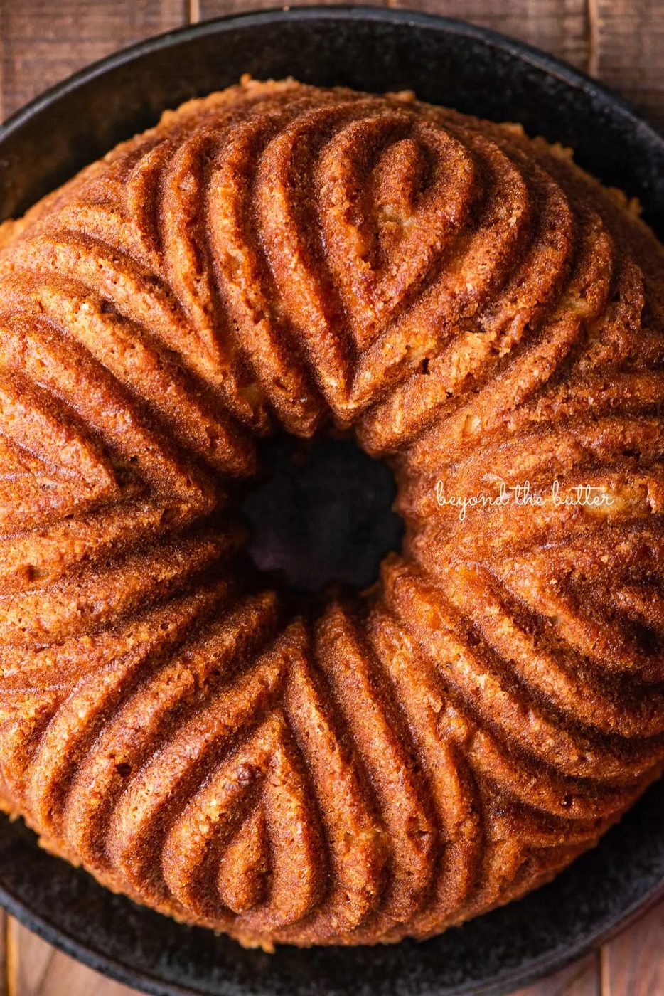 House-made apple bundt cake on black ceramic plate and dark wood background | © Sovuh