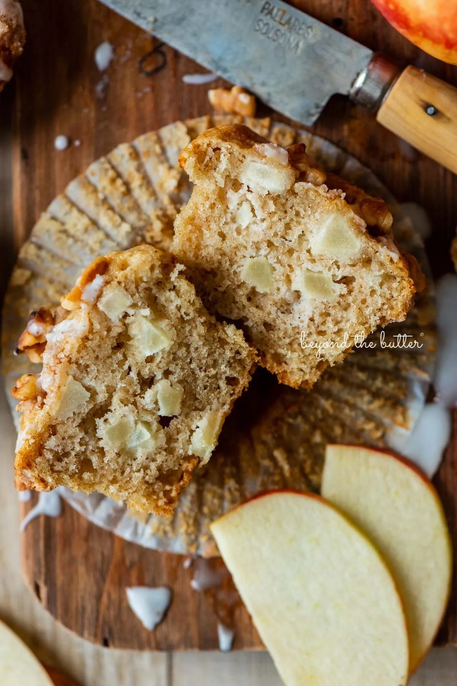 Sliced apple cinnamon streusel muffin on a wood cutting board with sliced apples | © Sovuh