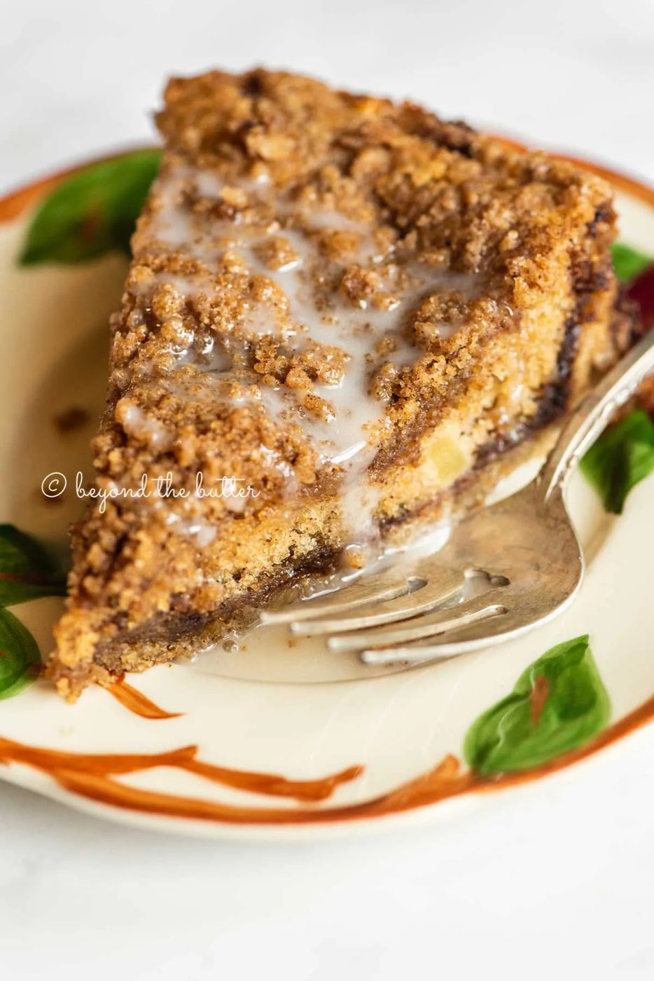 Slice of apple coffee cake on a dessert plate close up | All Images © Sovuh