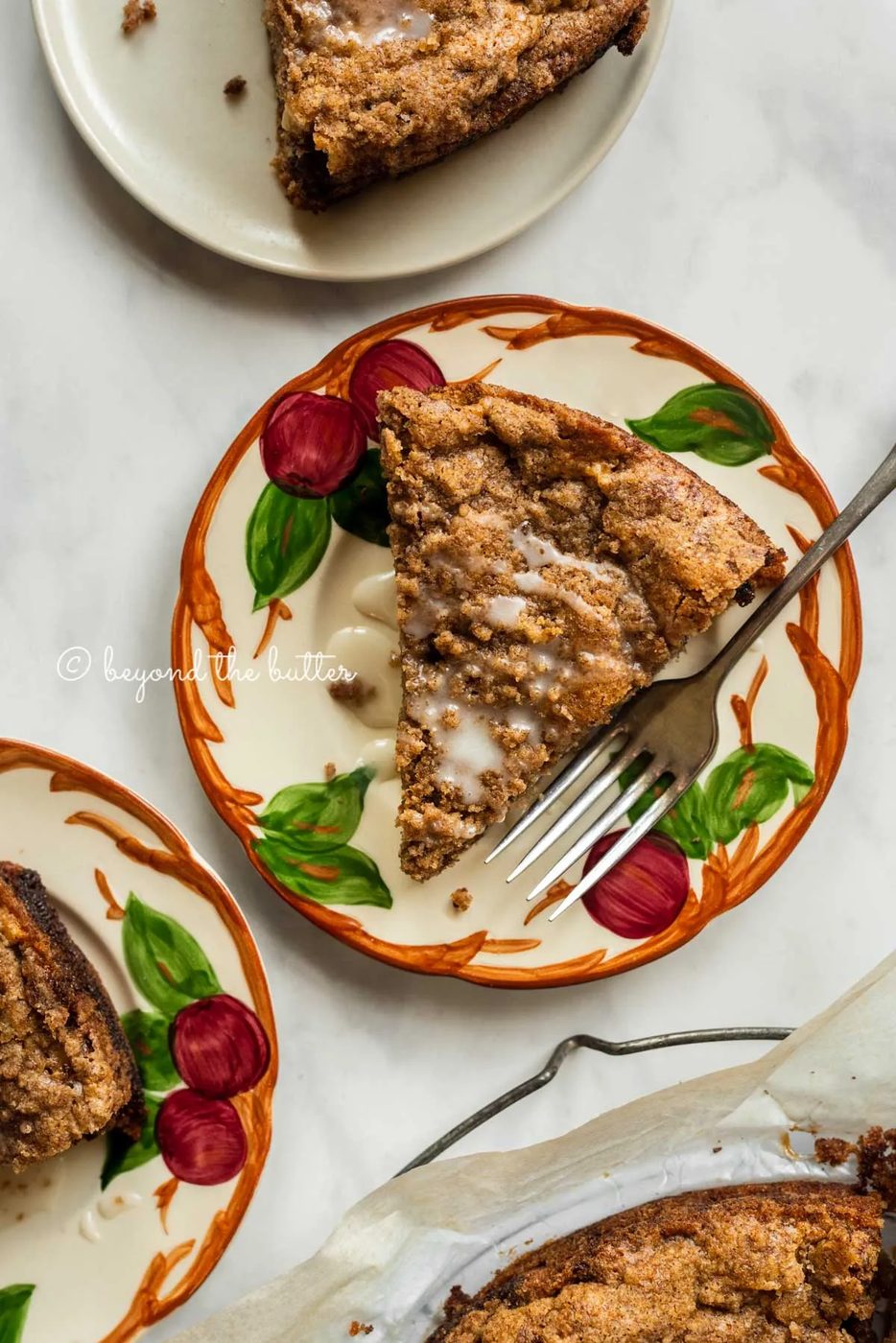 Slices of warm apple coffee cake on dessert plates drizzled with a simple vanilla glaze | All Images © Sovuh