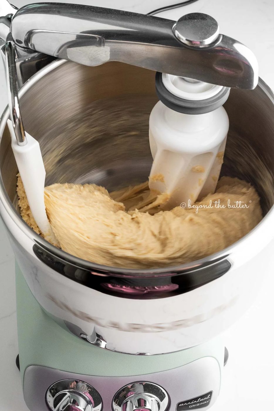 Cinnamon roll dough being kneaded in an Ankarsrum Assistent Original mixer in nordic sage.