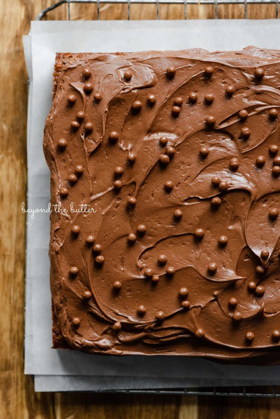 Banana chocolate chip snack cake with chocolate cream cheese frosting on parchment paper and wire cooling rack | All images © Sovuh
