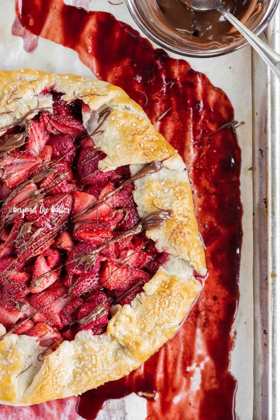 Overhead image of a Berry Nutella Galette on a baking sheet with Nutella drizzled over the top | All Images © Sovuh