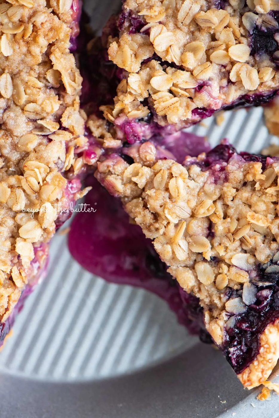 Slices of blueberry crumble pie in pie plate with scoopy of ice cream in the center | © Sovuh