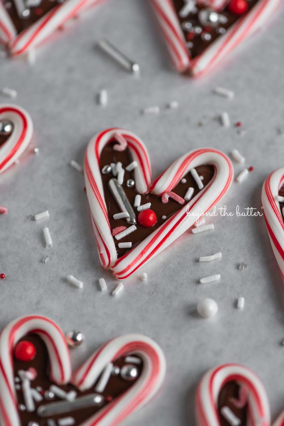 Candy cane hearts on parchment paper | © Sovuh