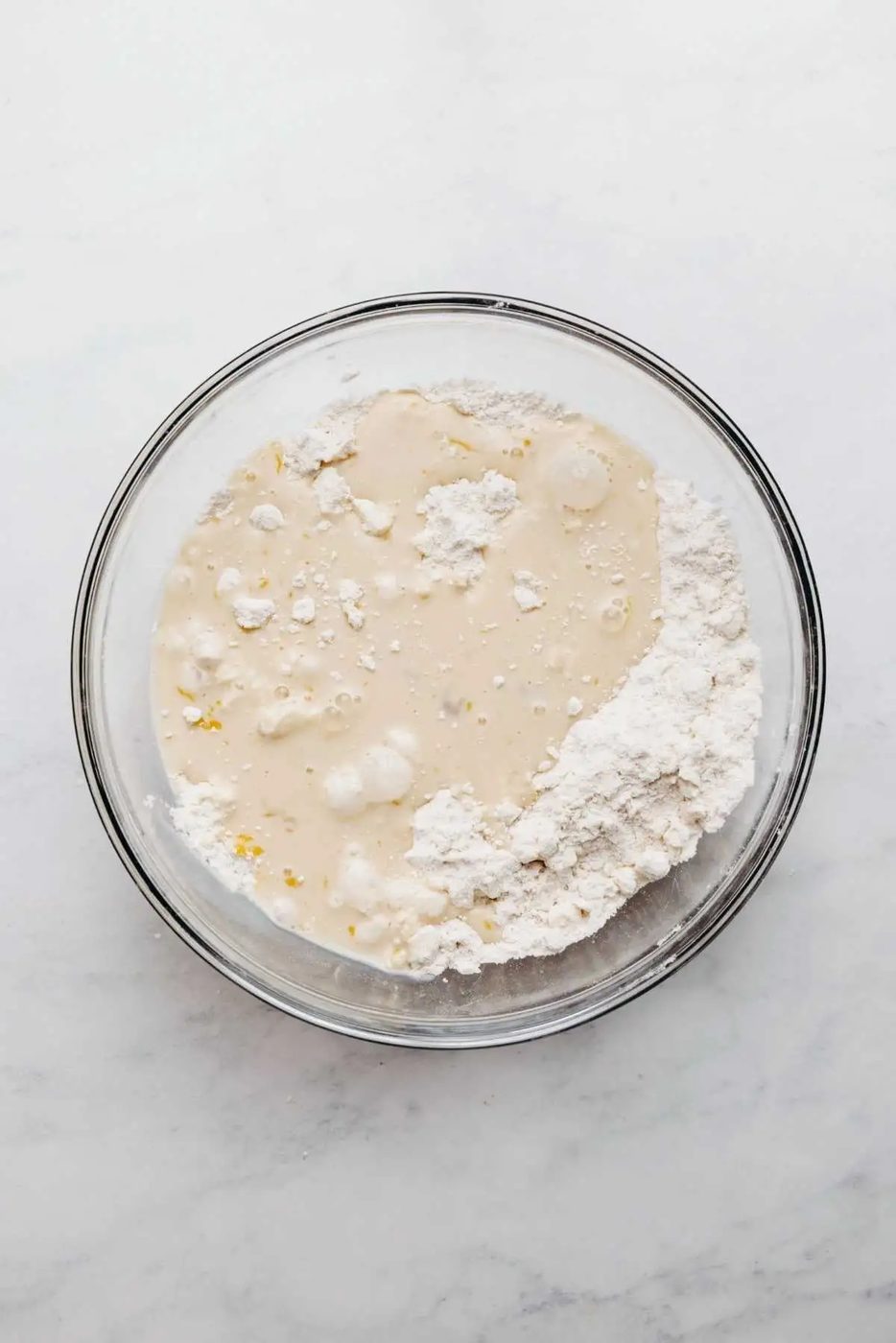 Whisked egg, milk, and vanilla extract with flour mixture added to the bowl.