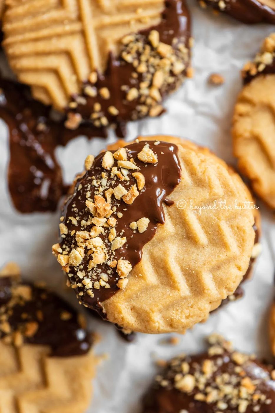 Baking sheet with randomly placed and stacked chocolate dipped peanut butter cookies | All Images © Sovuh