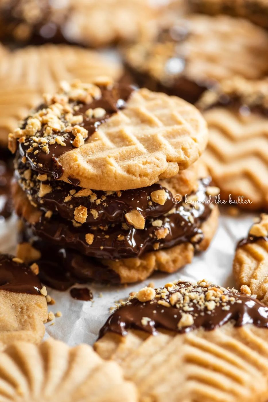Baking sheet with randomly placed and stacked chocolate dipped peanut butter cookies | All Images © Sovuh