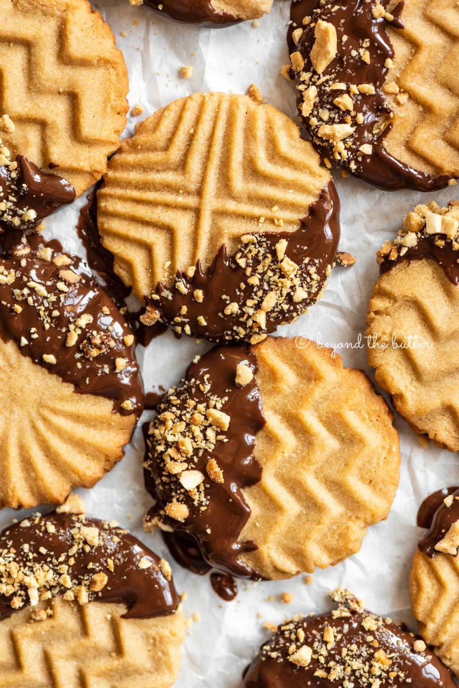 Baking sheet with randomly placed chocolate dipped peanut butter cookies | All Images © Sovuh