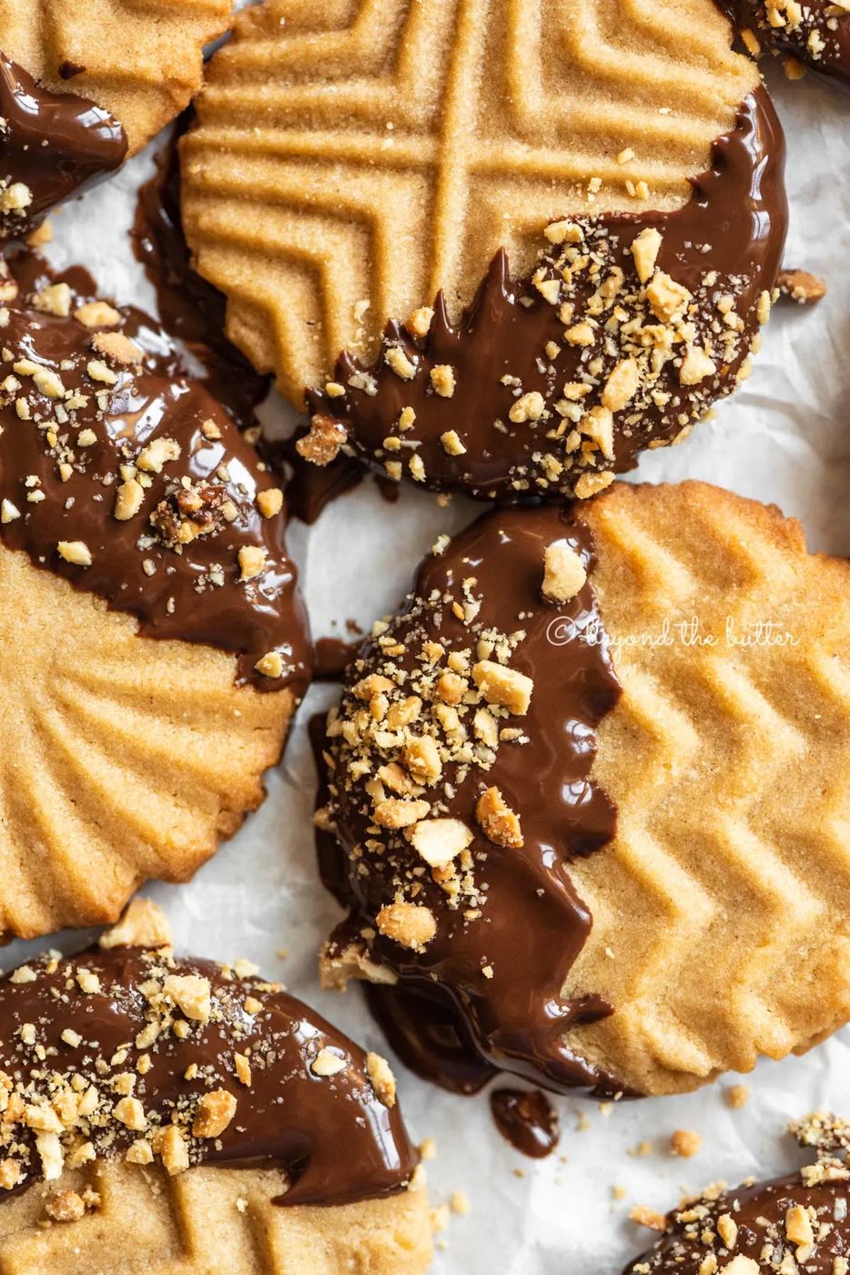 Baking sheet with randomly placed chocolate dipped peanut butter cookies | All Images © Sovuh