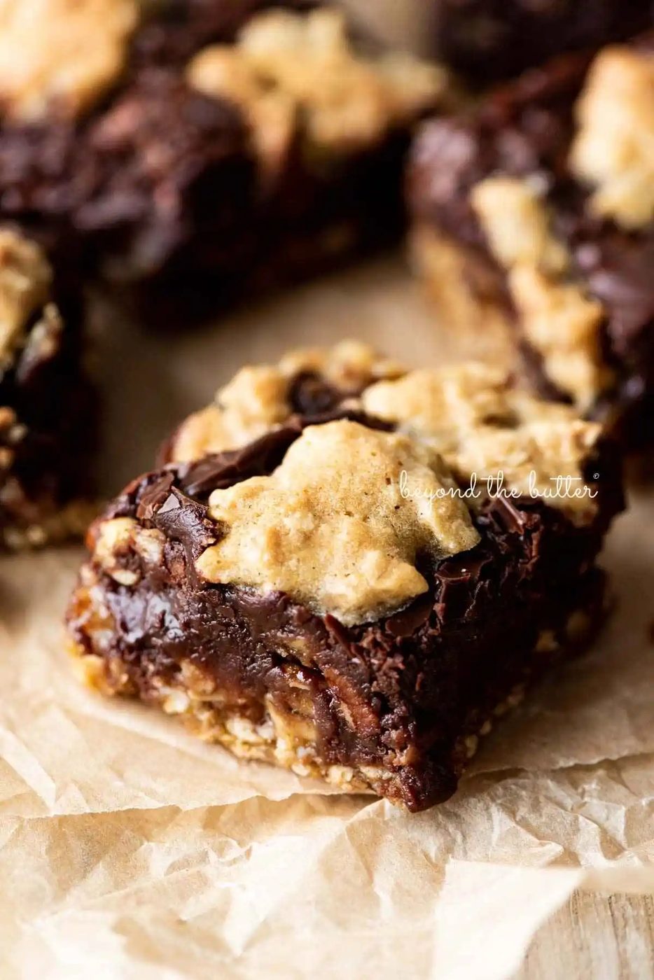 Oatmeal fudge nut bars randomly placed on crinkled brown parchment paper.