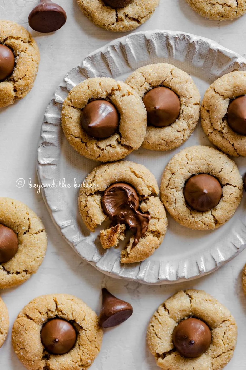Small dessert plate full of familiar peanut butter blossoms with one melted and split apart | All Images © Sovuh