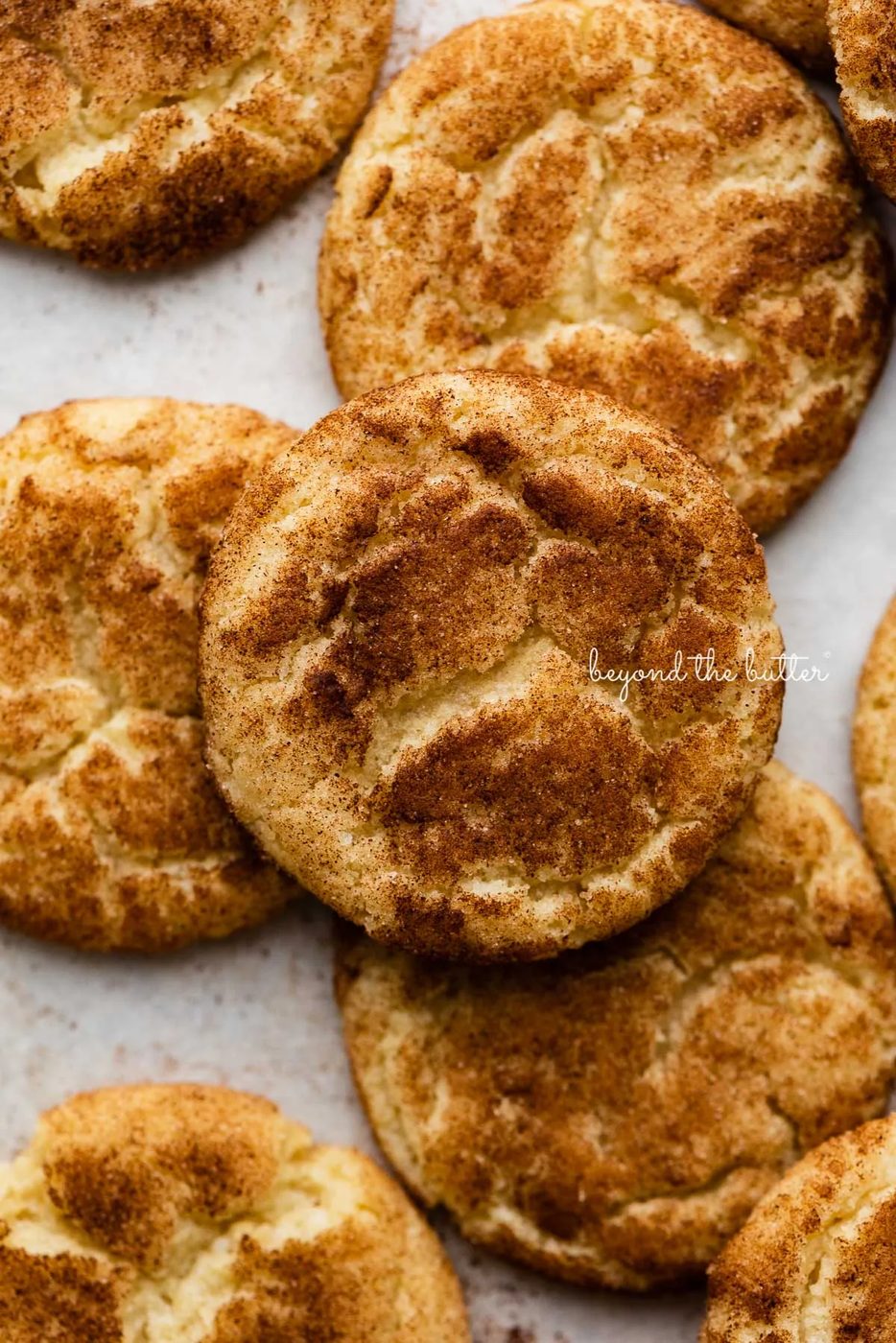 Snickerdoodle cookies on a parchment paper lined baking sheet | © Sovuh