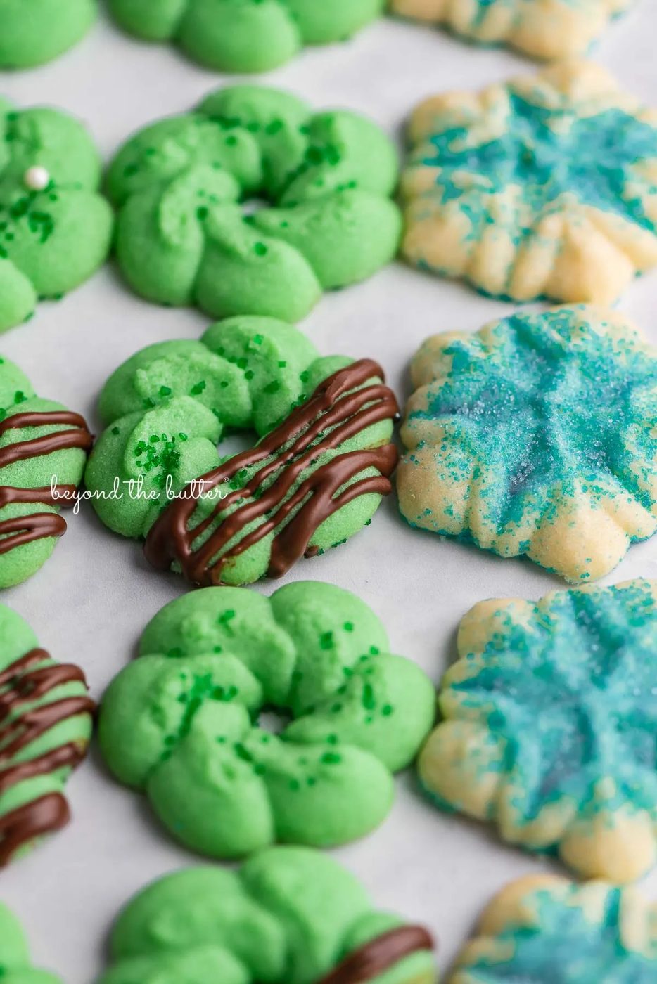 Decorated familiar buttery spritz cookies lined up on a white marbled background | © Sovuh
