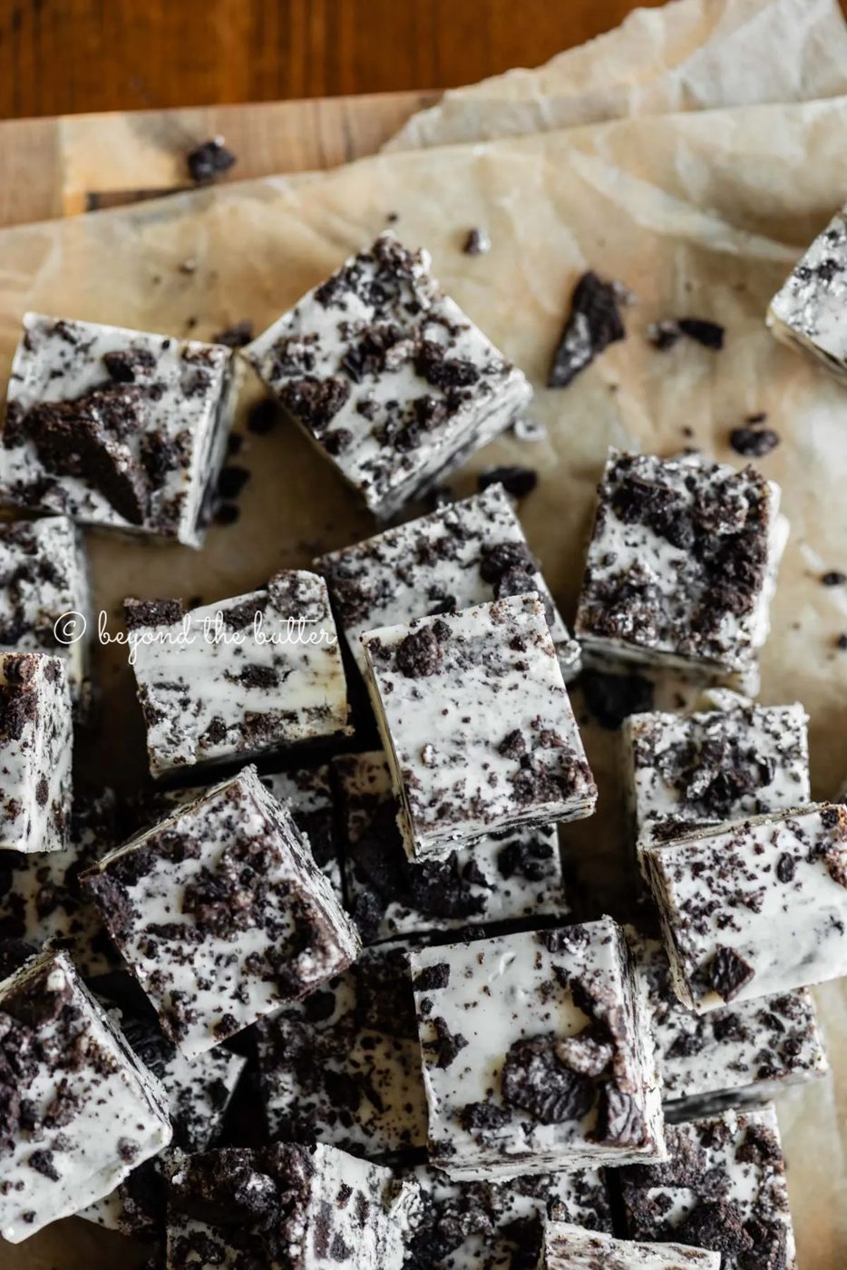 Pieces of cookies and cream fudge randomly placed on top of brown parchment paper | All Images © Sovuh