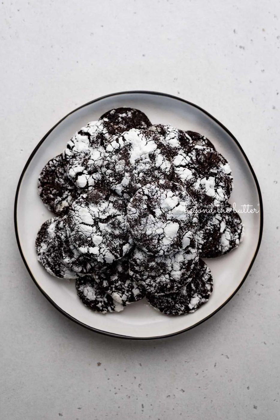 Dessert plate of dark chocolate crinkle cookies on light gray background | © Sovuh