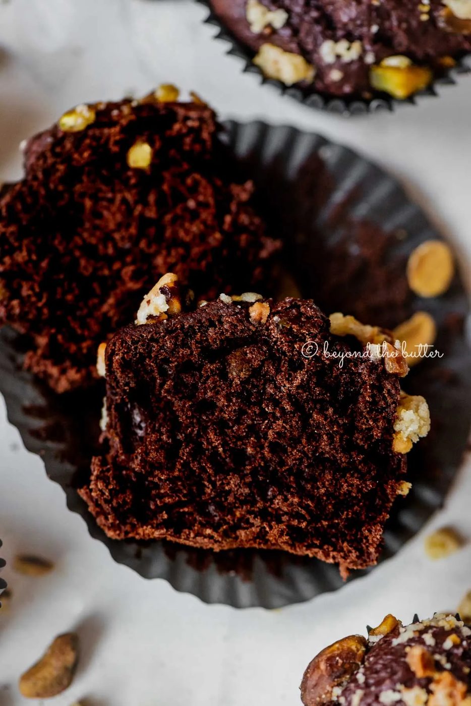 Dark chocolate pistachio cream cheese muffins with center muffin unwrapped and cut in half | All Images © Sovuh