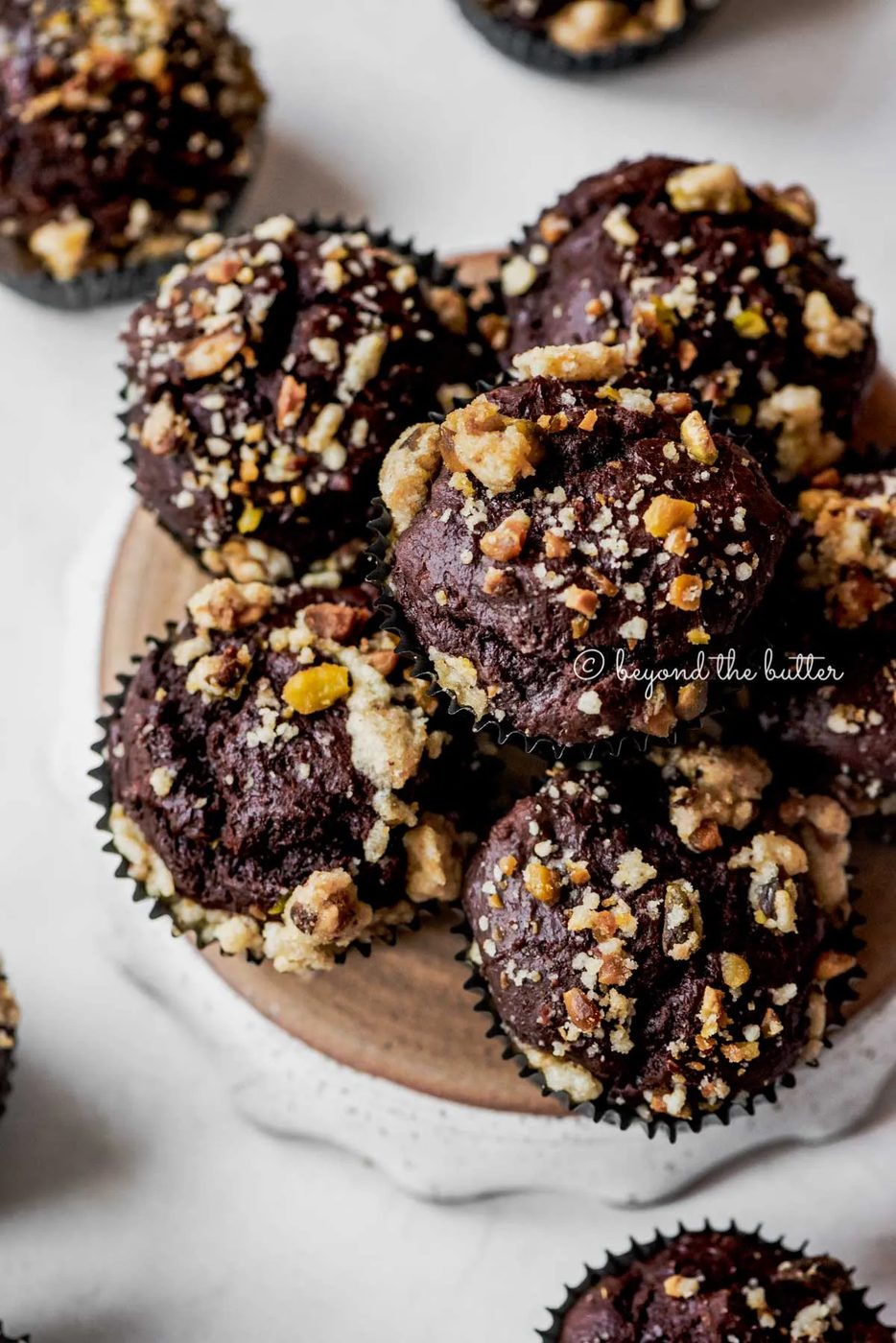 Small plate of dark chocolate pistachio cream cheese muffins on gray background | All Images © Sovuh