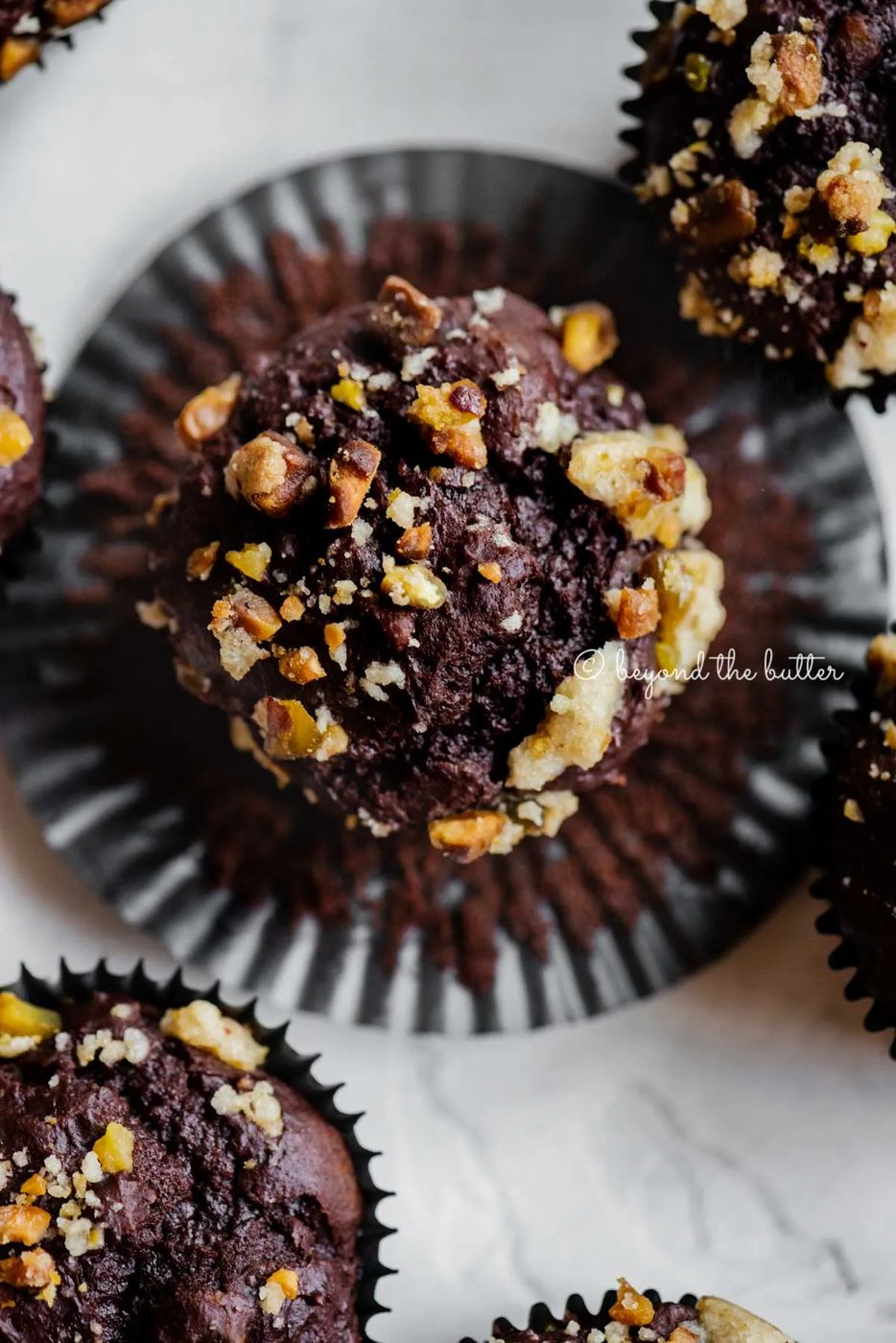 Dark chocolate pistachio cream cheese muffins with center muffin unwrapped | All Images © Sovuh