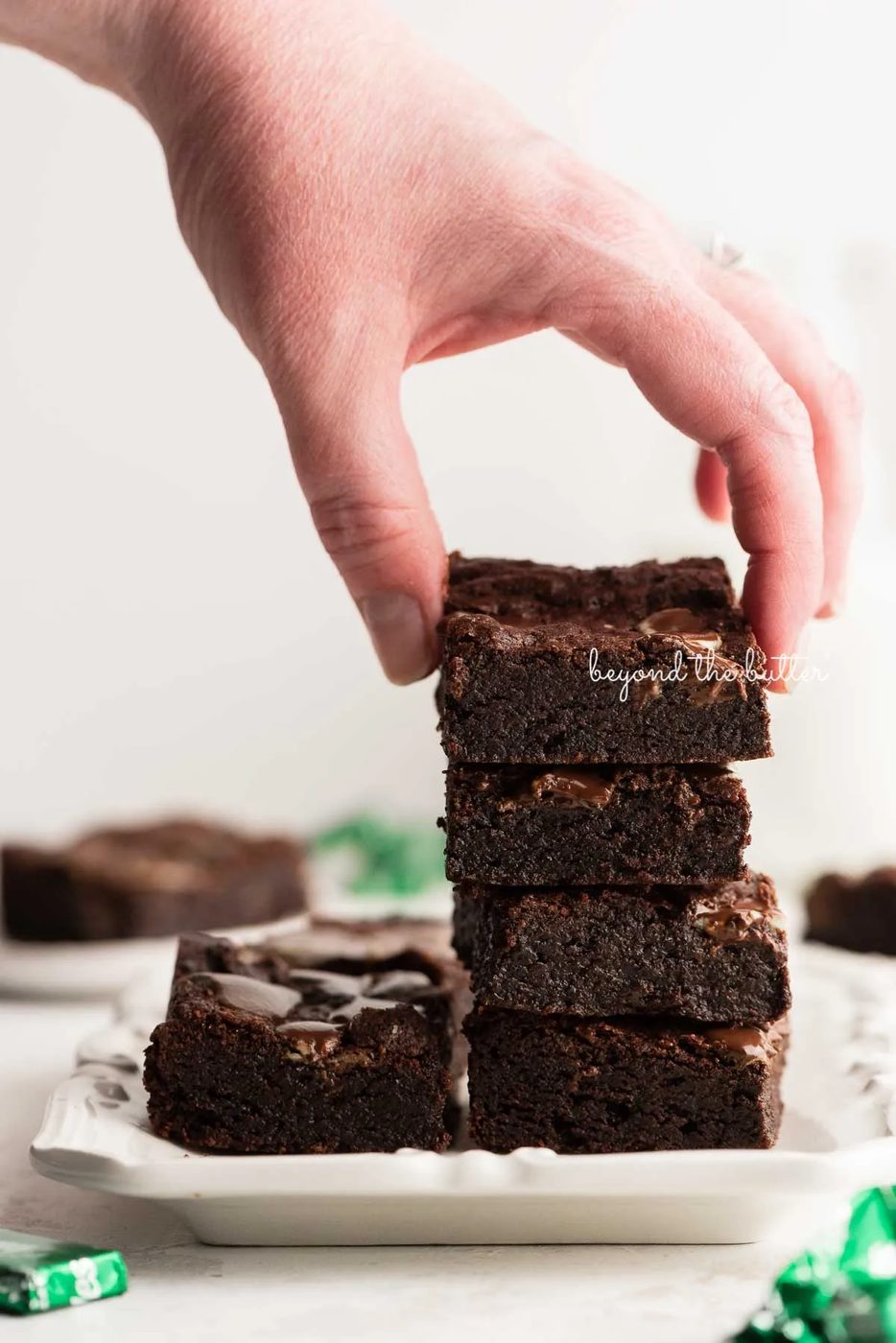 Stacking mint chocolate brownies on a white dessert plate | © Sovuh