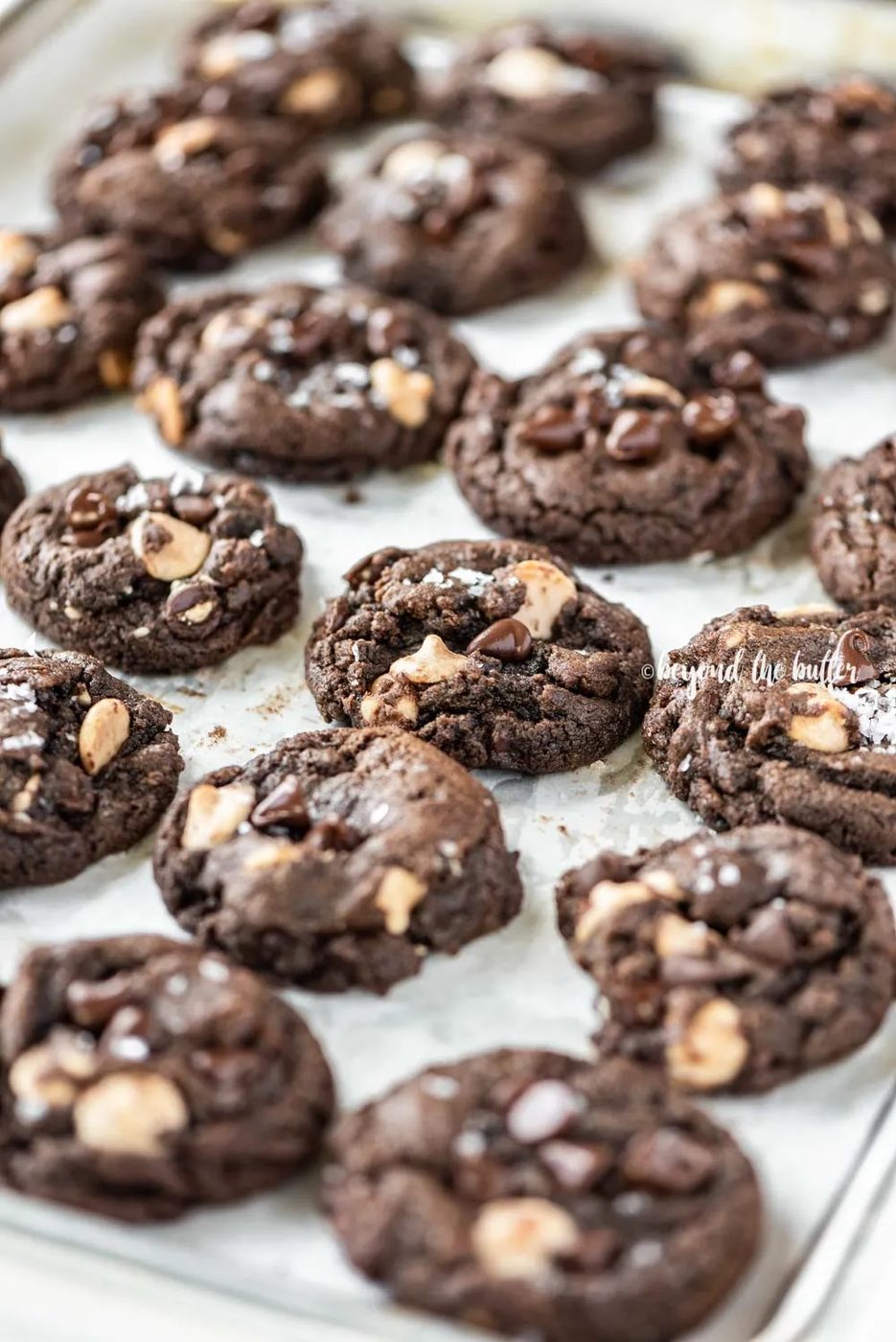 Angled image of just baked double chocolate salted caramel cookies on a baking sheet | All Images © Sovuh