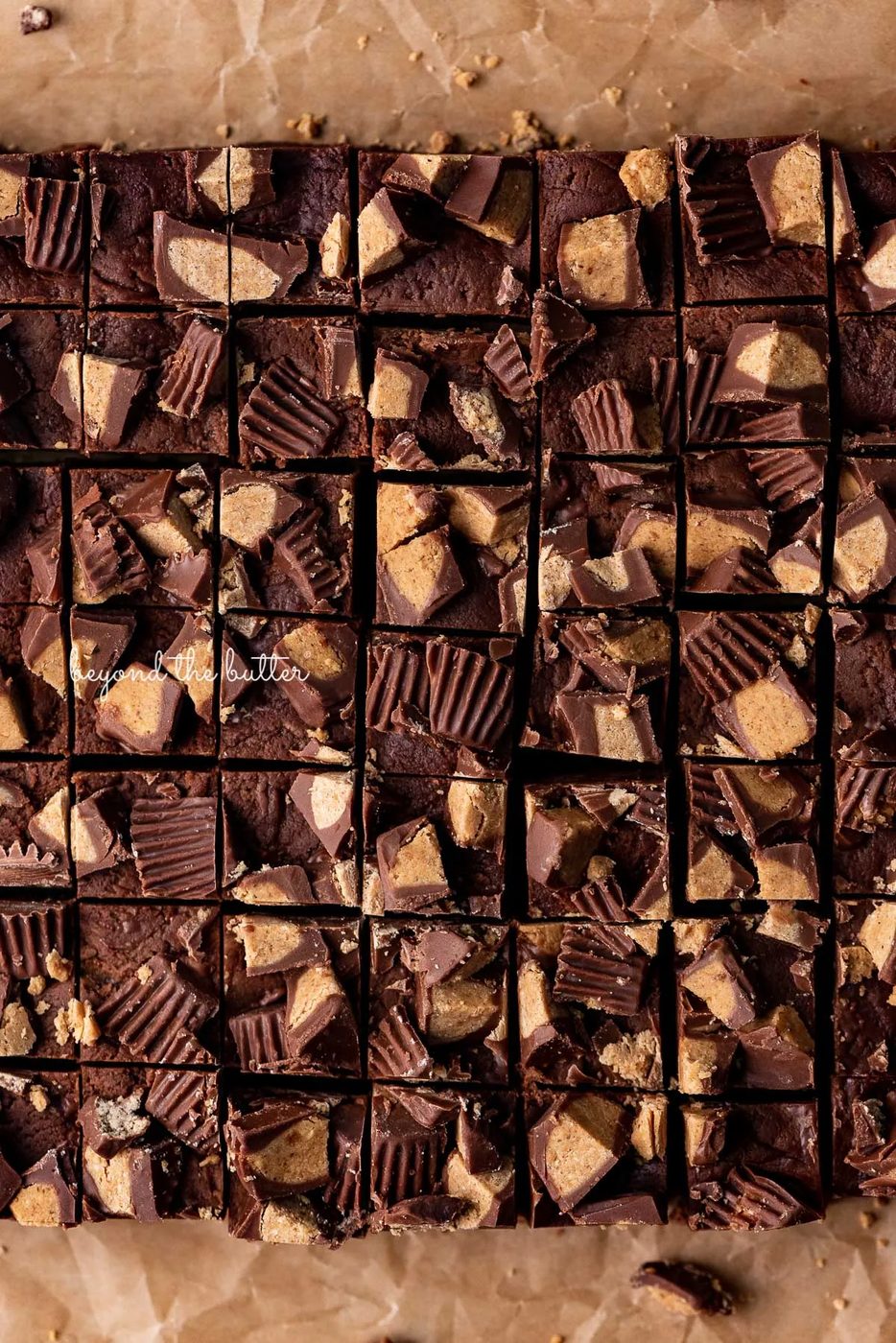 Easy chocolate peanut butter fudge cut into small 1 inch squares on brown parchment paper | © Sovuh