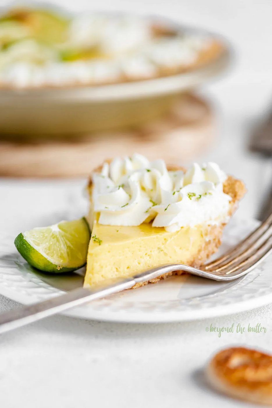 Easy Key Lime Pie decorated with house-made whipped cream, puff pastry twists, and sliced limes | Image and Copyright Policy: © Sovuh, LLC