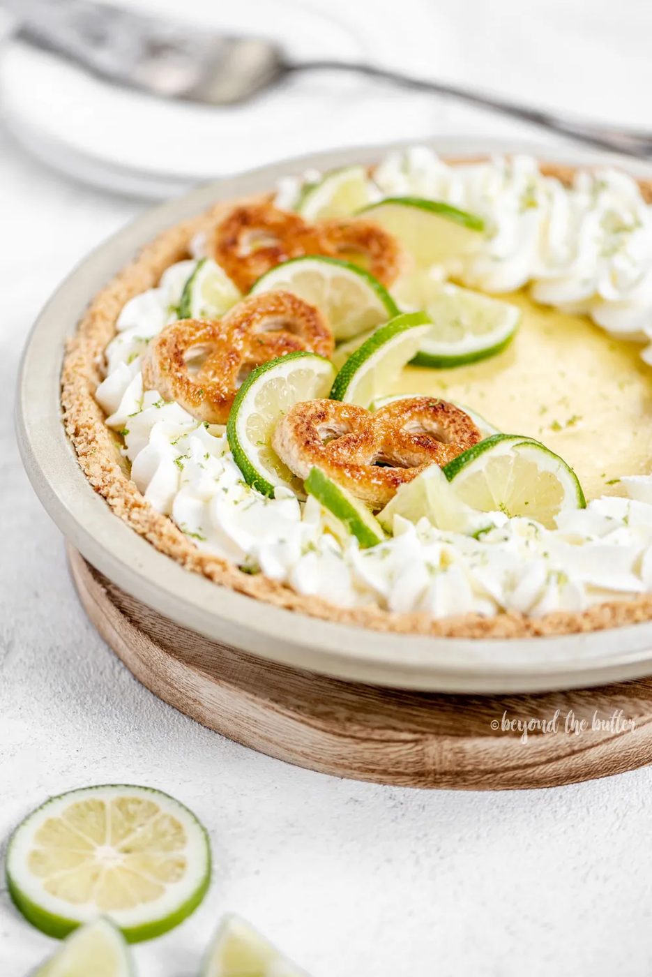 Easy Key Lime Pie decorated with house-made whipped cream, puff pastry twists, and sliced limes | Image and Copyright Policy: © Sovuh, LLC