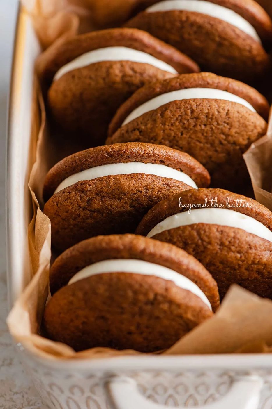 Natural parchment paper lined ceramic baking pan with house-made gingerbread whoopie pies | © Sovuh
