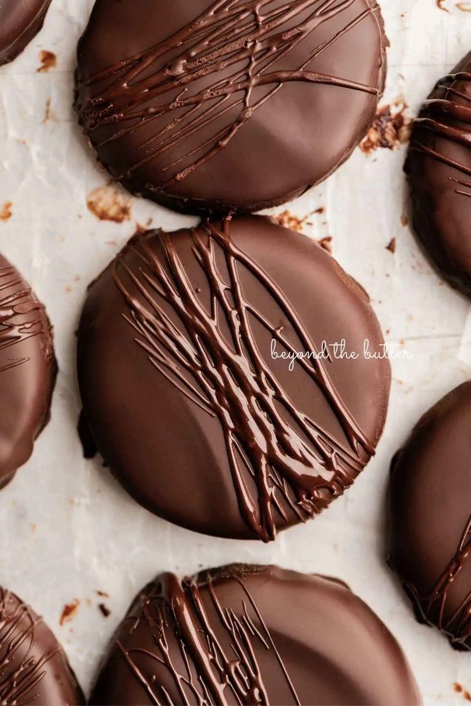 Chocolate dipped thin mints on a wax paper lined baking sheet.