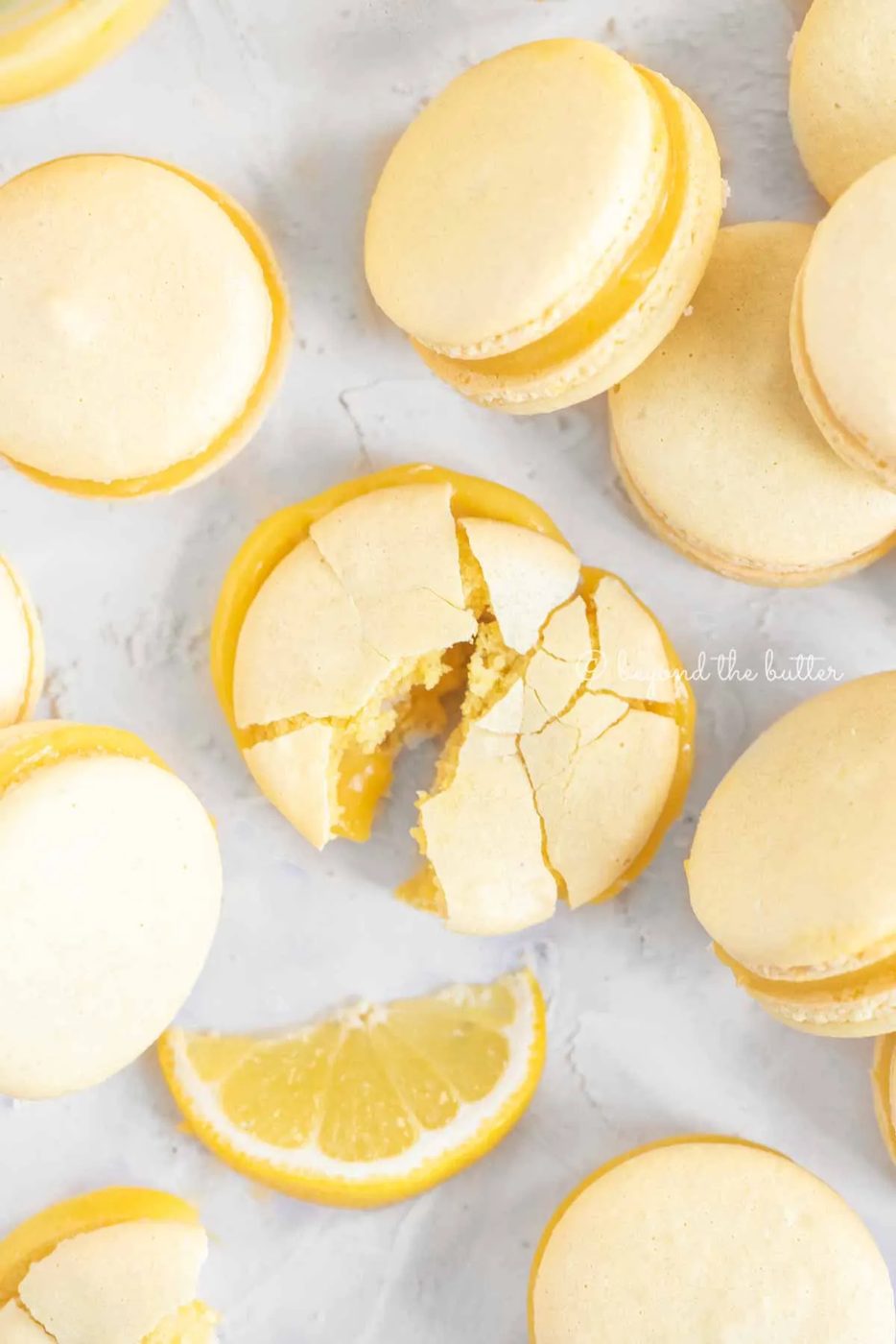 Overhead image randomly placed lemon macarons with the center macaron broken apart | All Images © Sovuh
