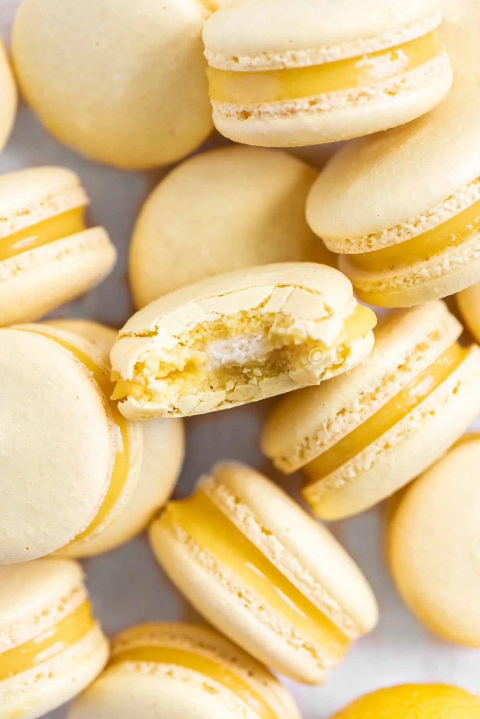 Randomly placed lemon macarons with a bite taken out of the center macaron | All Images © Sovuh