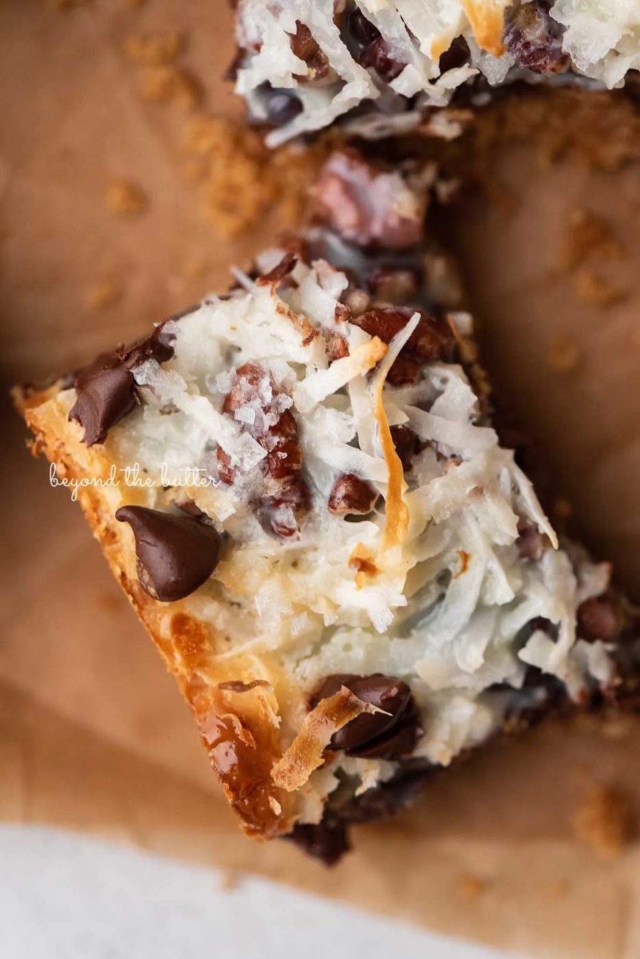 Magic cookie bars on brown parchment paper | © Sovuh