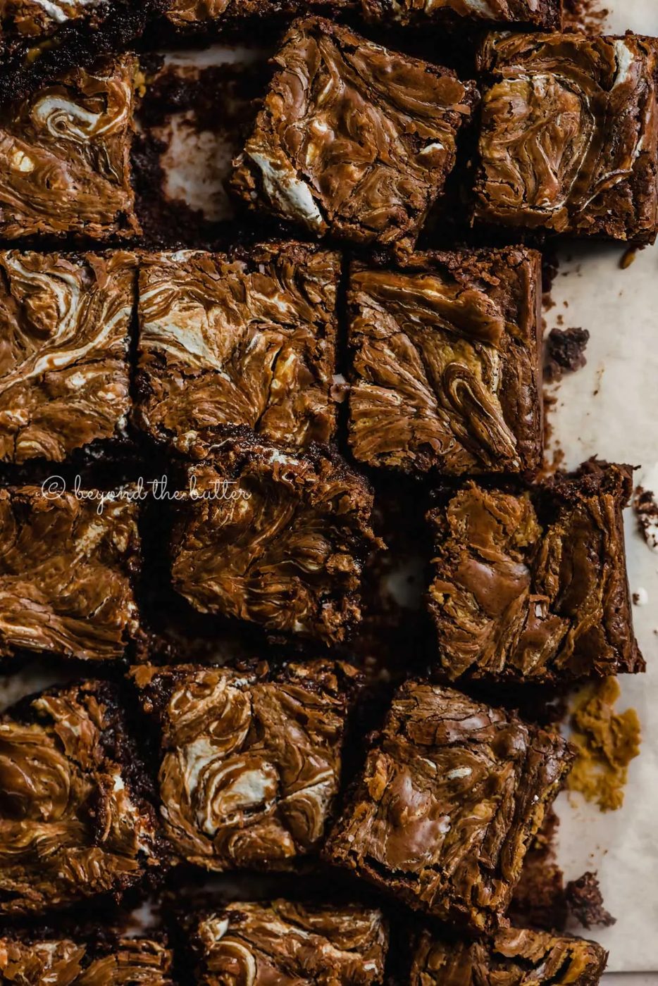 Randomly arranged marshmallow peanut butter brownies on parchment paper | All Images © Sovuh