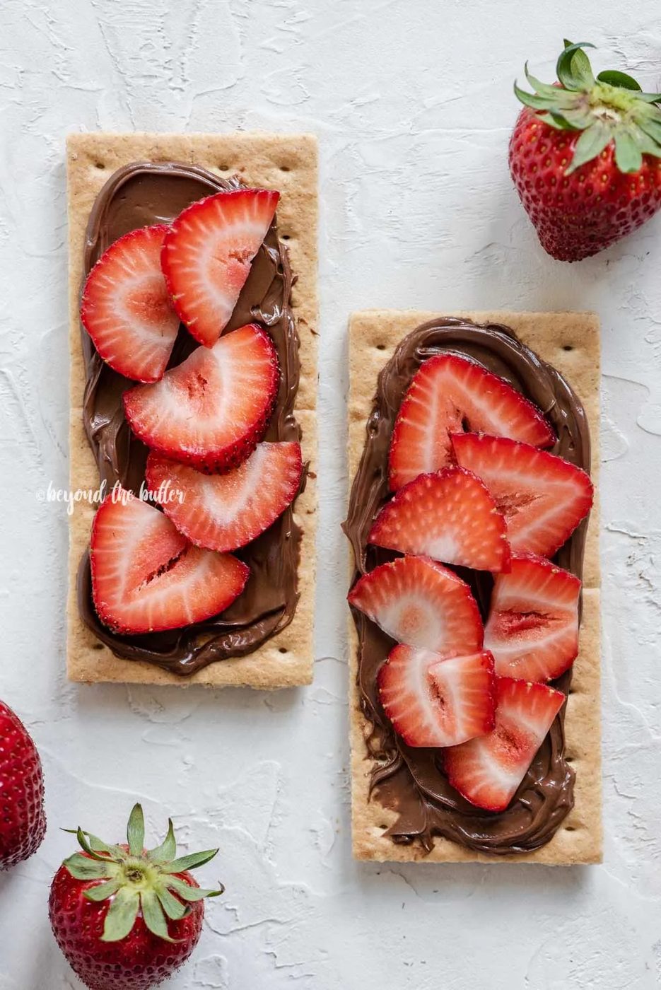 Image of strawberries and nutella spread over top of 2 graham crackers | All Images © Sovuh