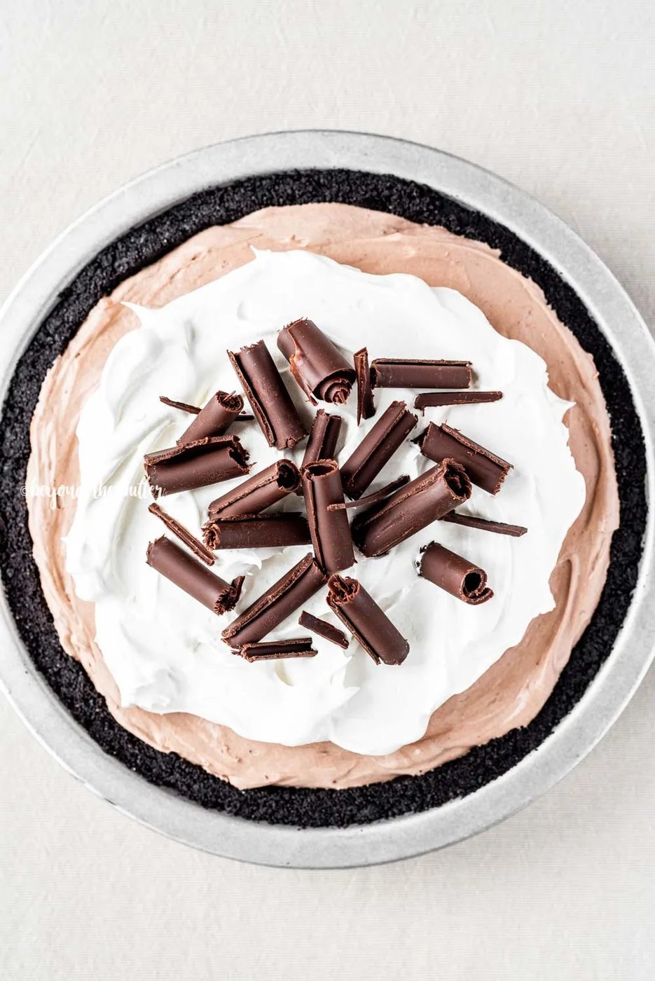Overhead image of No-Bake Chocolate Cream Pie garnished with Cool Whip and chocolate curls | All Images © Sovuh