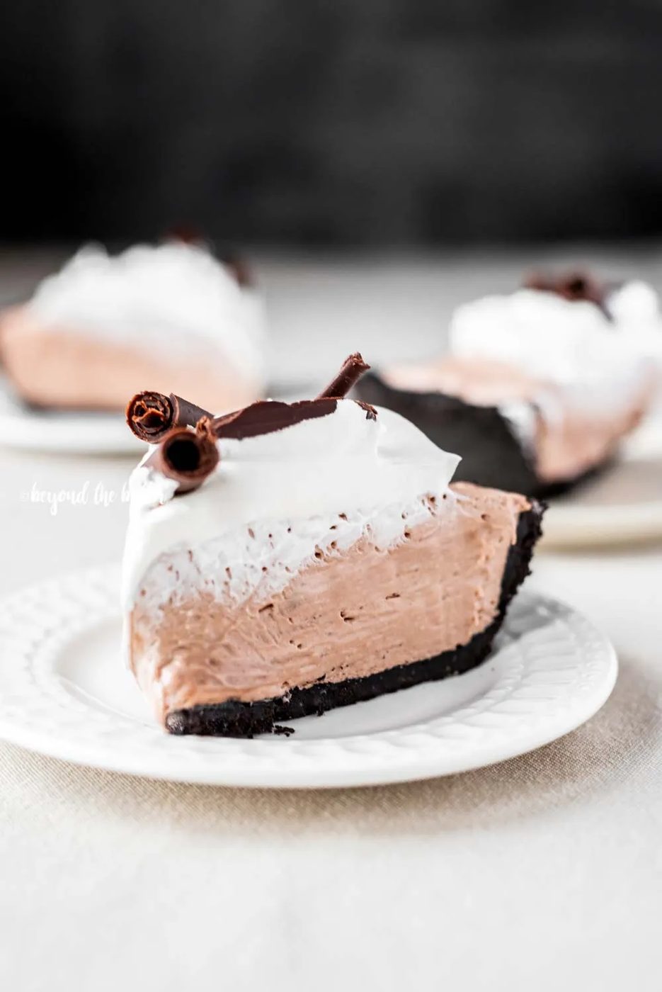 Slice of no-bake chocolate cream pie with chocolate wafer crust on dessert plates | All Images © Sovuh