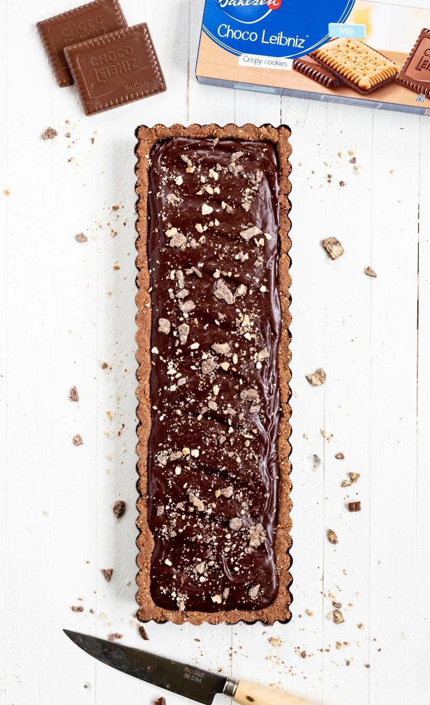No-bake Dark Chocolate Tart |Overhead image of No-Bake Dark Chocolate Tart with a box of the cookies above it and a cutting knife below | Image and Copyright Policy: © Sovuh, LLC