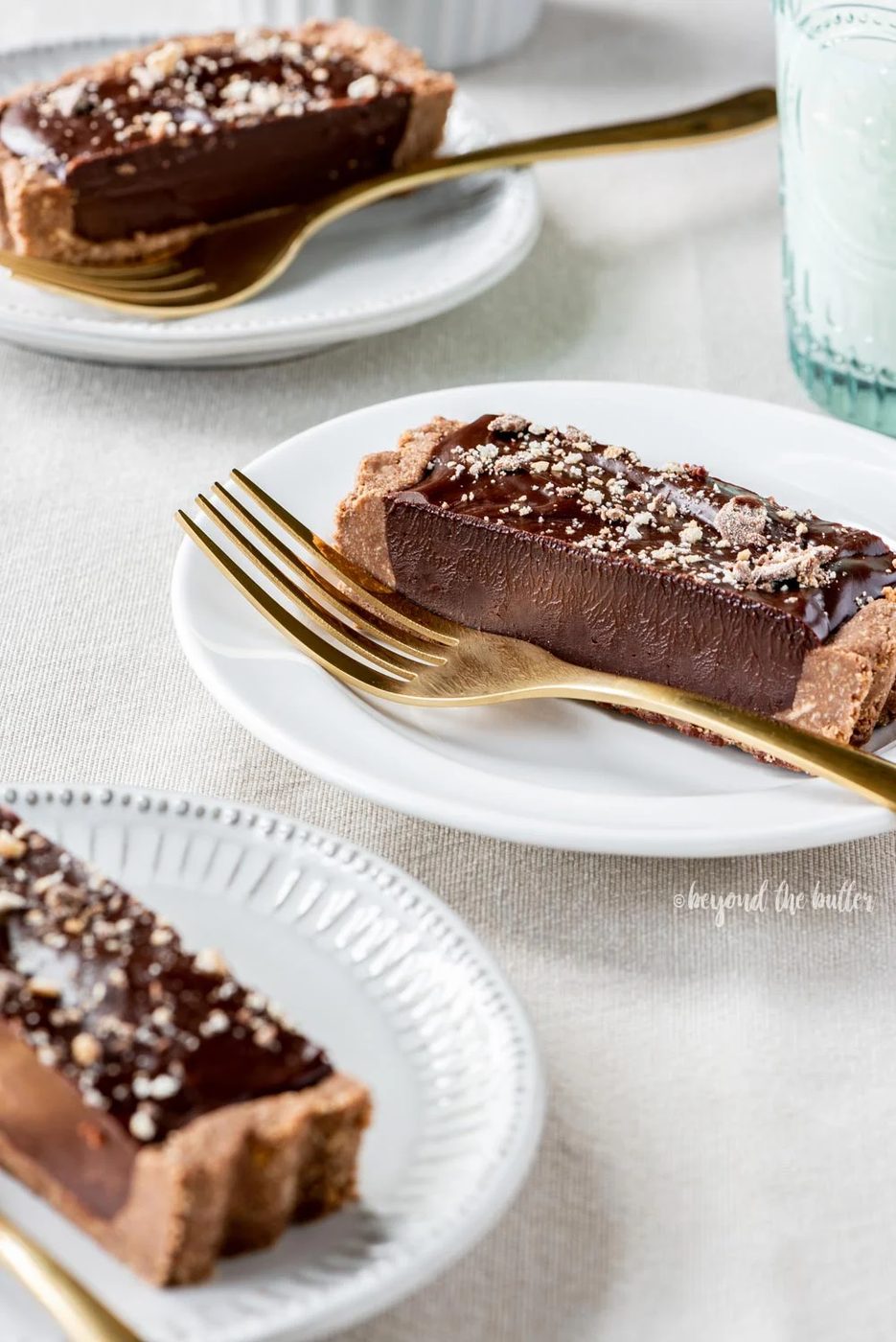 No-bake Dark Chocolate Tart | Slices of no-bake dark chocolate tart on dessert plates with forks and a glass of milk | Image and Copyright Policy: © Sovuh, LLC