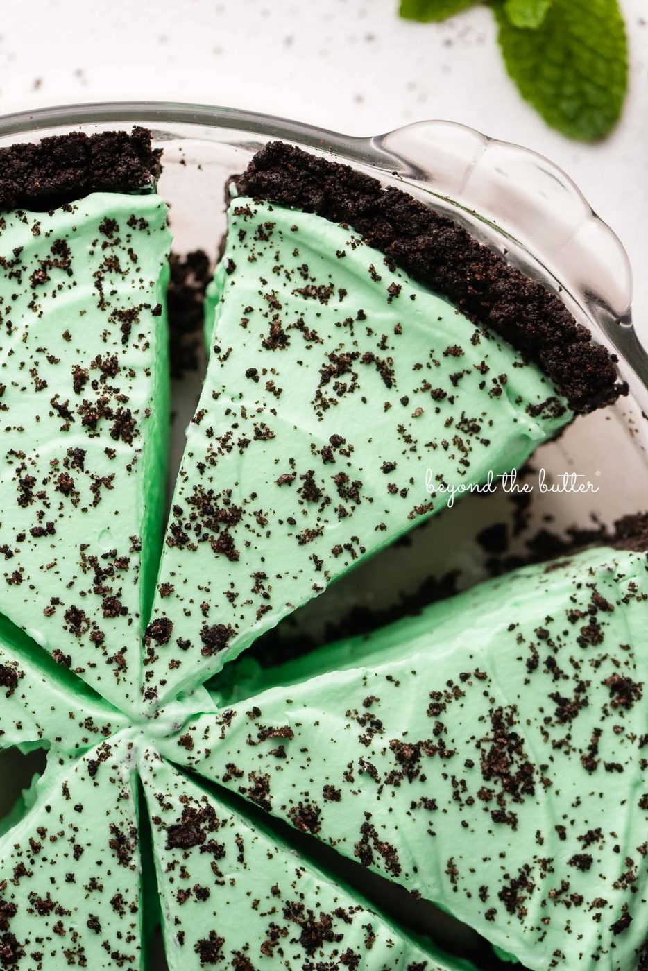 Slices of no bake mint chocolate pie in a glass pie plate on white background | © Sovuh