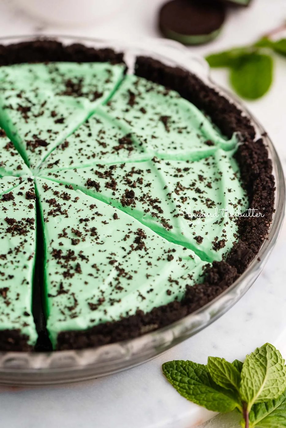 No bake mint chocolate pie sliced in a glass pie plate on a white background | © Sovuh