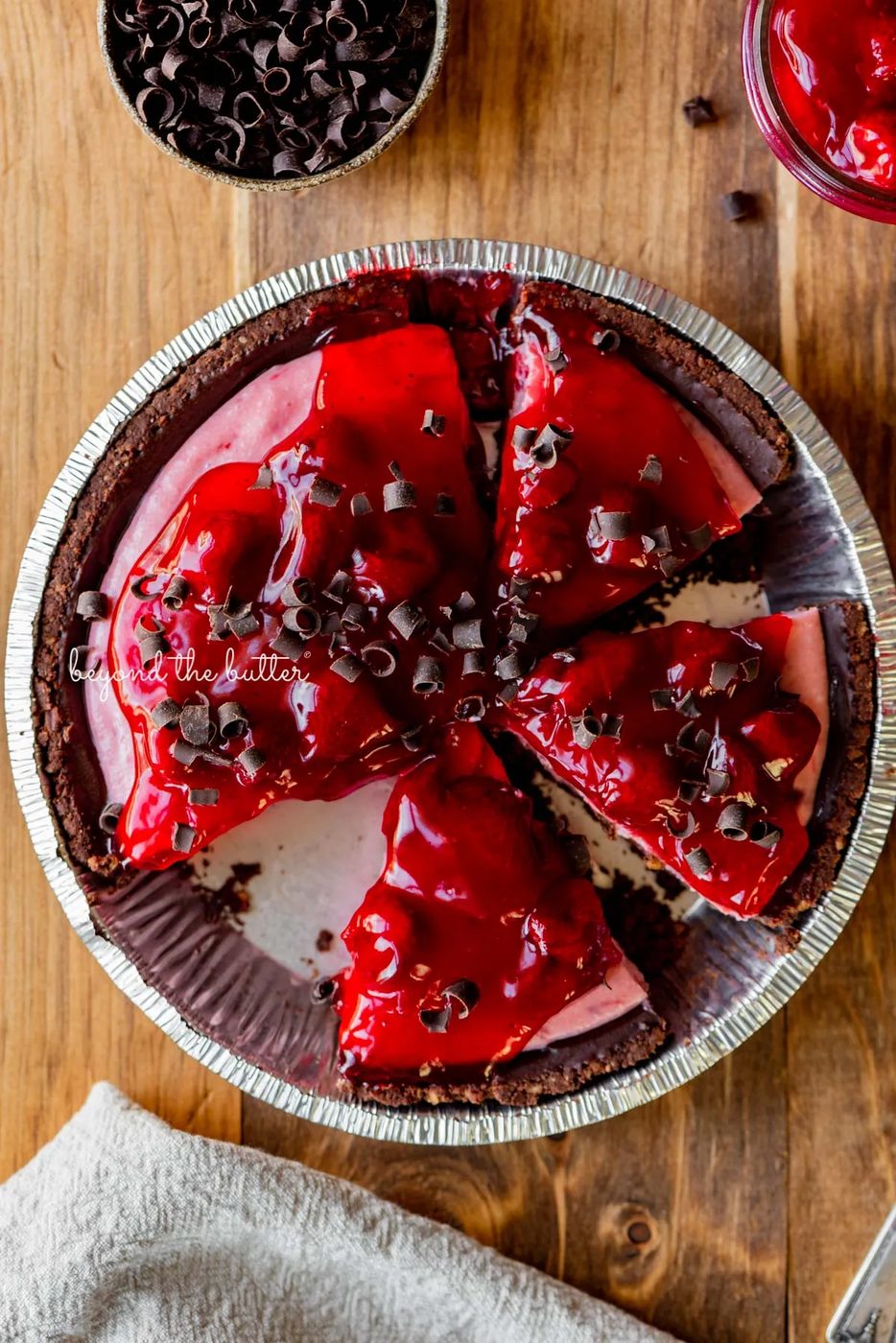 No bake strawberry chocolate pie with small bowl of chocolate curls and extra strawberry pie filling on wood table | All images © Sovuh