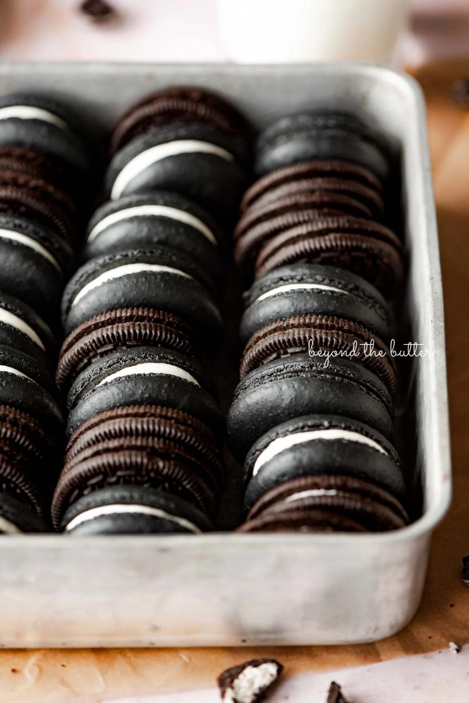 Oreo macarons and oreo cookies in a vintage baking tin on parchment paper | © Sovuh