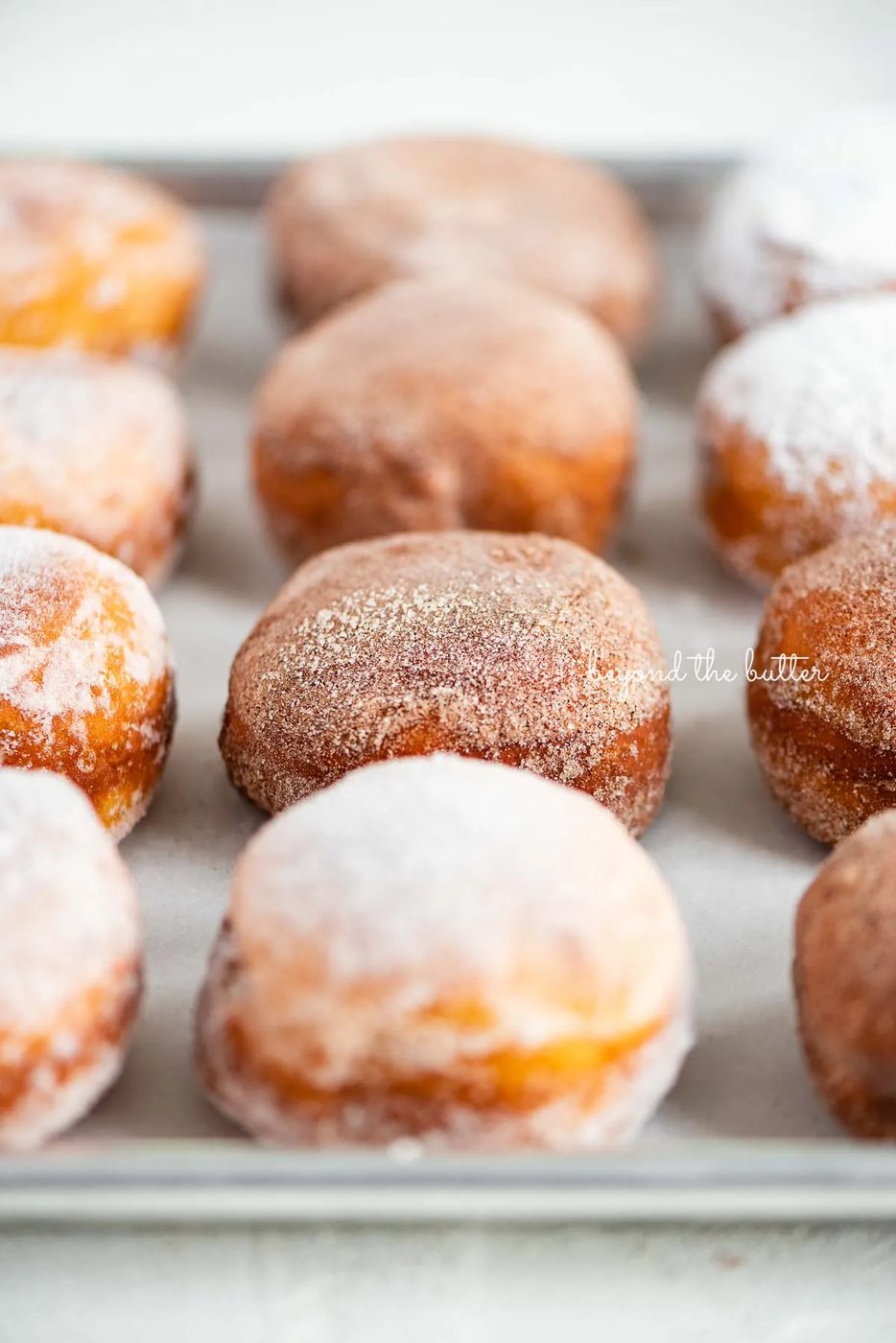 Fasnacht doughnuts on a parchment paper lined baking sheet | © Sovuh