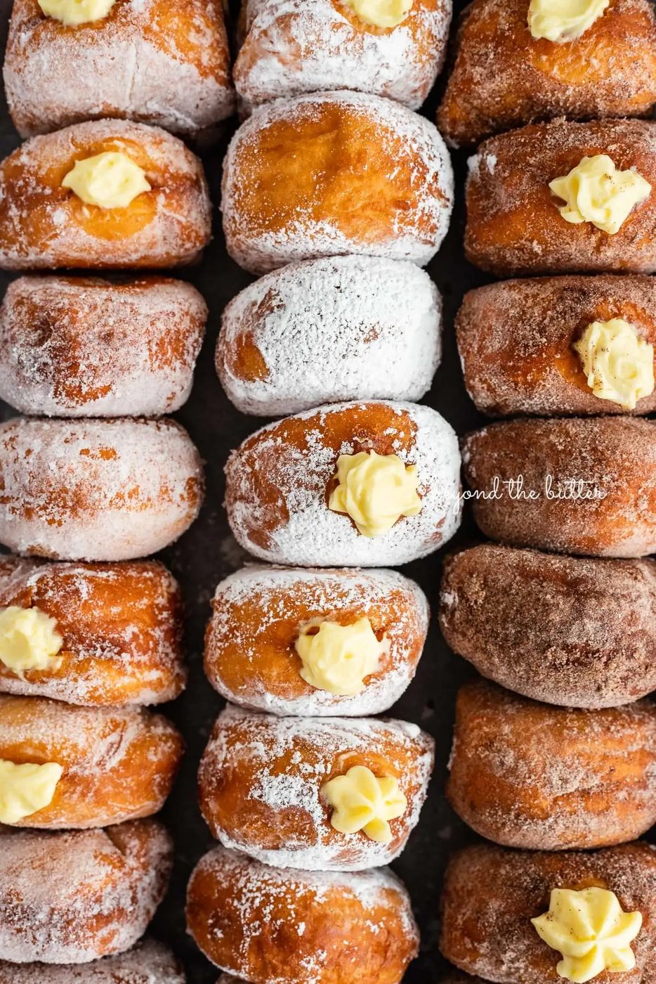 Rows of pennsylvania dutch fasnacht doughnuts filled with pastry cream | © Sovuh