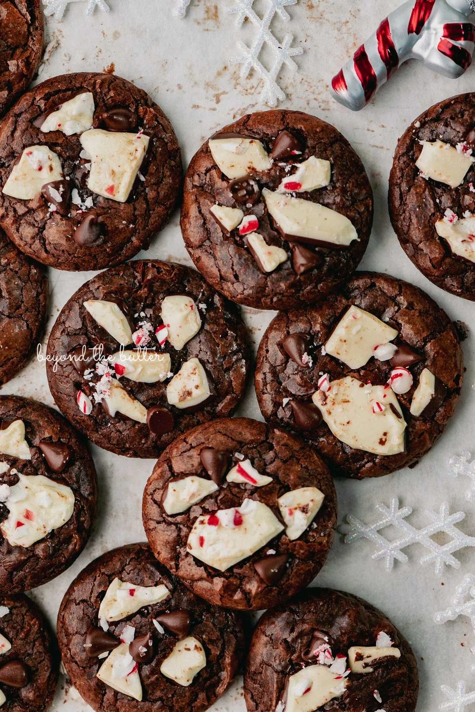 Just baked peppermint bark brownie crinkle cookies on a parchment paper lined baking sheet | © Beyond the Buter