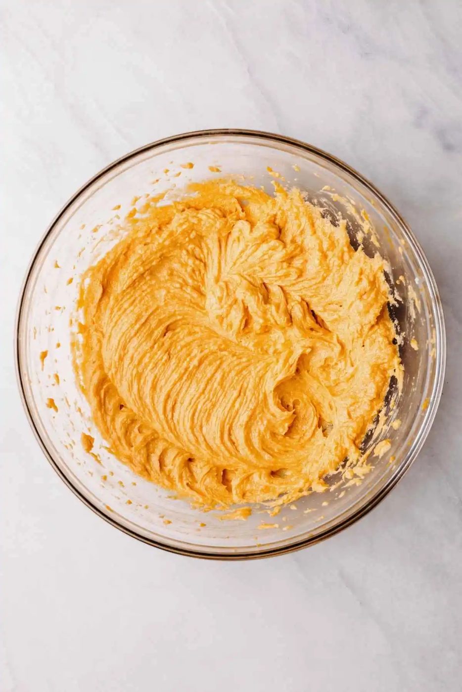 Egg, pumpkin puree, and vanilla extract blended into the shortening and sugar in large glass mixing bowl.