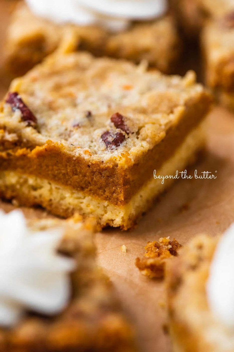 Sliced pumpkin pie cake bars on parchment paper background | © Sovuh