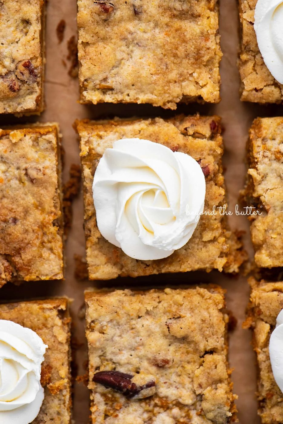 Sliced pumpkin pie cake bars on parchment paper background | © Sovuh