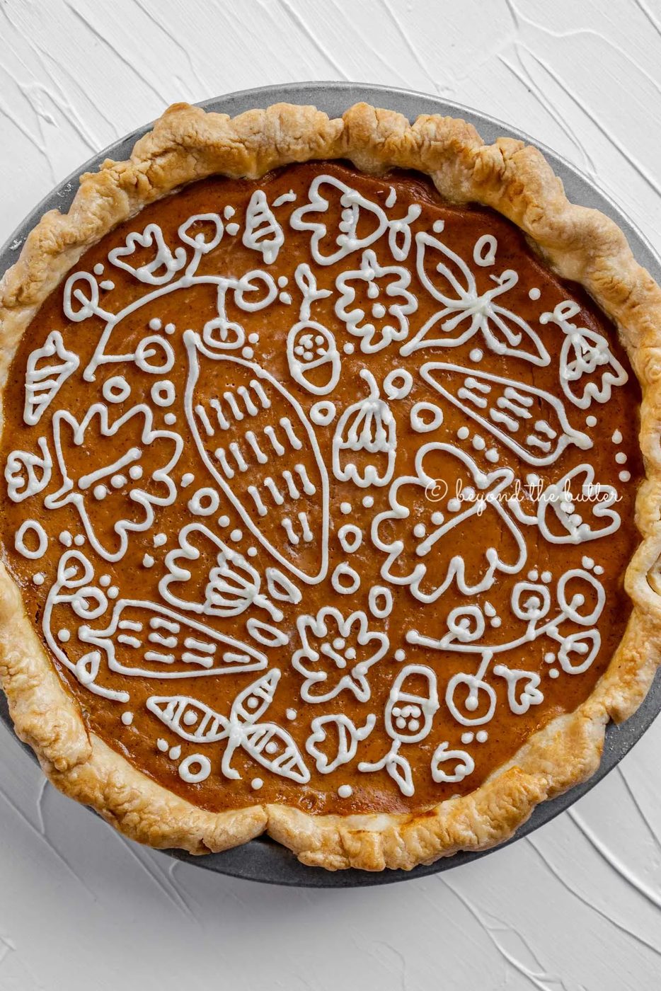 Overhead image of pumpkin pie with a piped cream cheese frosting decoration | All images © Sovuh